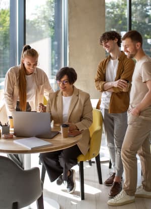 A group of people around a laptop working out a strategy