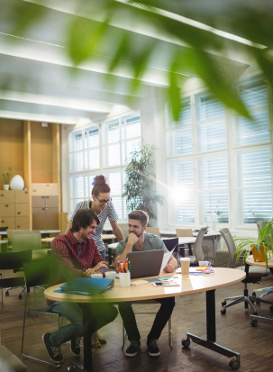 A group of people around a laptop working out a strategy